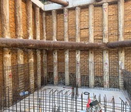 Construction site with wooden formwork and steel reinforcement bars for foundation.